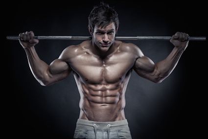 Muscular bodybuilder guy doing exercises with dumbbells over black background